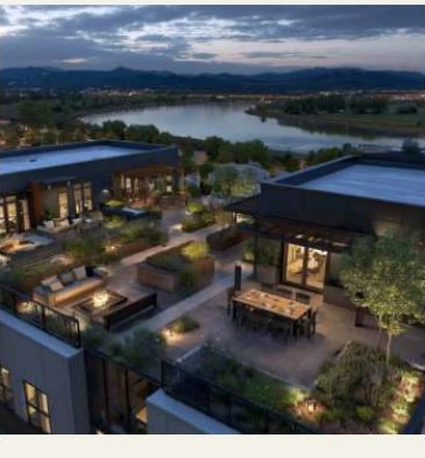 A Pacific Northwest river valley at dusk, with mountains in the distance and a green-roofed terrace in the foreground.